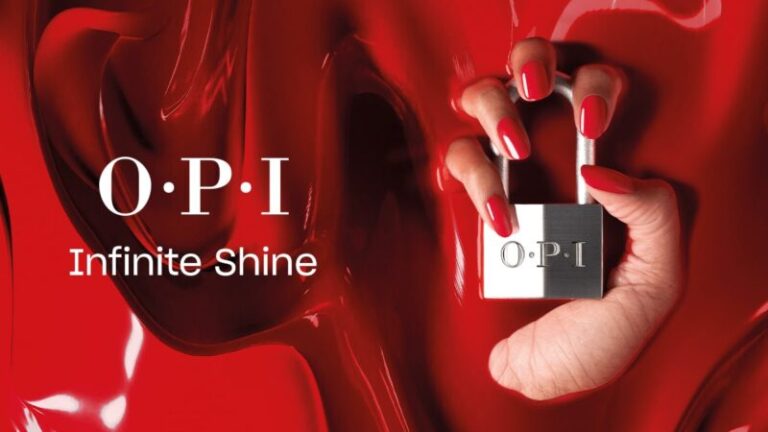 kobieca dłoń w czerwonej farbie trzymająca kłódkę