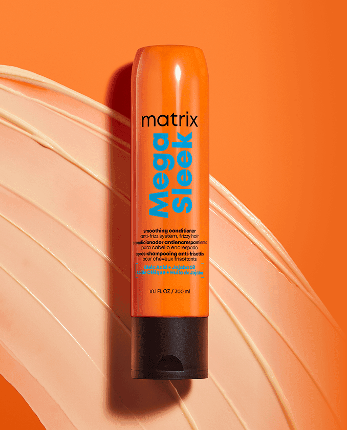 Treść wiadomości Gemini Odżywka Matrix Mega Sleek w pomarańczowej tubie, ułożona na rozsmarowanej, kremowej konsystencji na pomarańczowym tle.